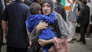 فلسطينية تندفع مع طفلها إلى المشفى بعد قصف إسرائيلي بخان يونس AFP